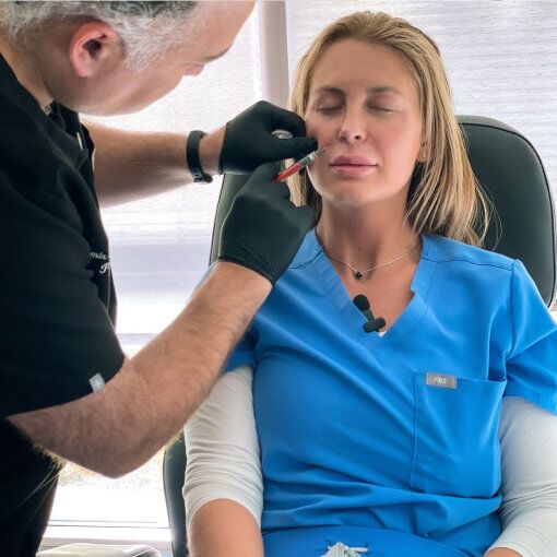 Provider performing a cosmetic injection treatment on a woman’s face