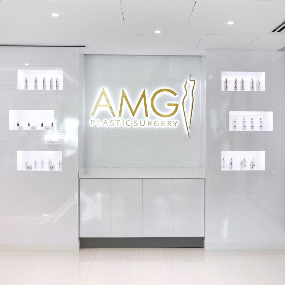 AMG Plastic Surgery logo on the reception area wall
